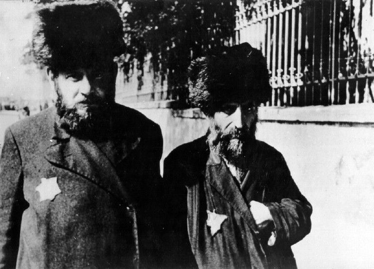 Two ultra - Orthodox Jews from Slovakia. On their coats is a yellow badge.